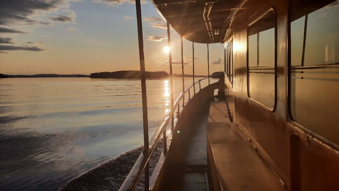 Risteilylaivan kylki ilta-auringossa Heinävedellä Pohjoisella Saimaalla – rauhallinen järviristeily alueen aktiviteettina.