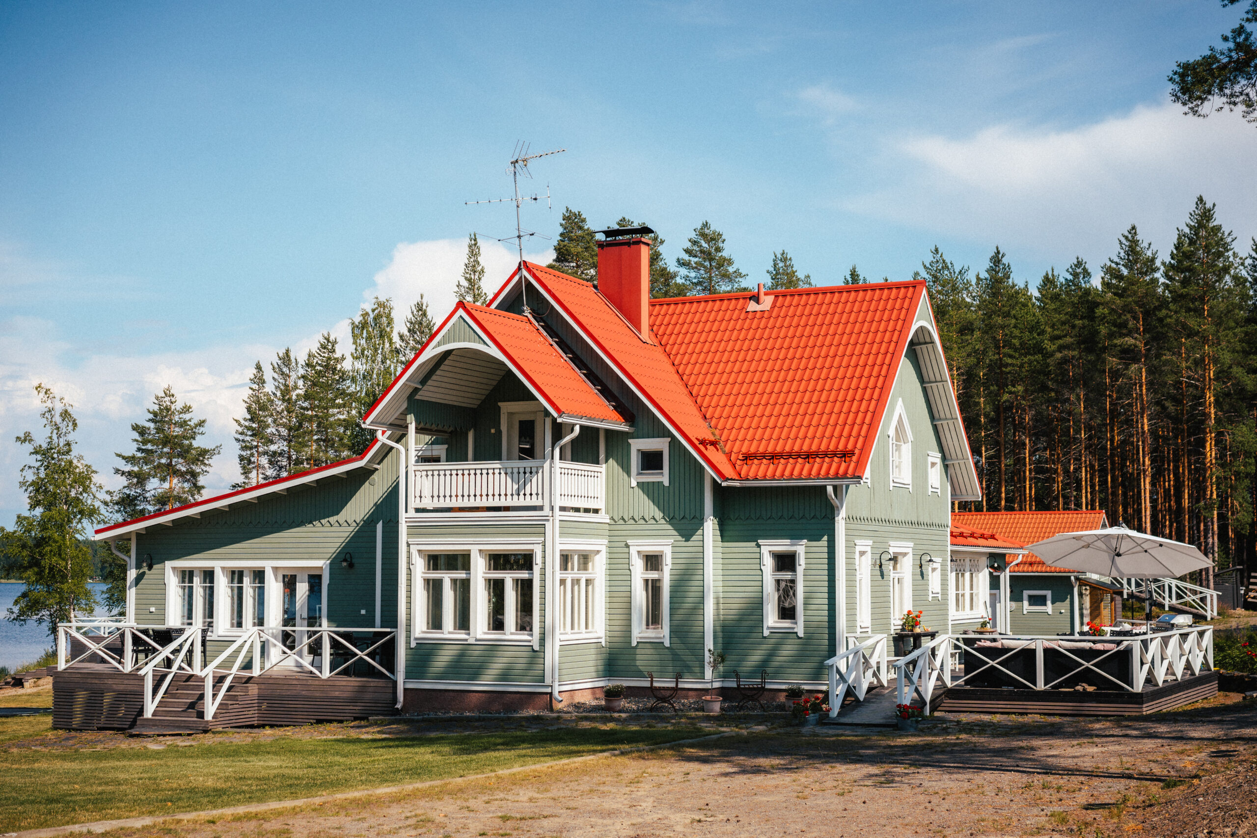 Villa Ruusulan päärakennus kesäisessä pihapiirissä Rääkkylässä Pohjoisella Saimaalla – viehättävä majoitus- ja juhlakohde järvimaisemassa.