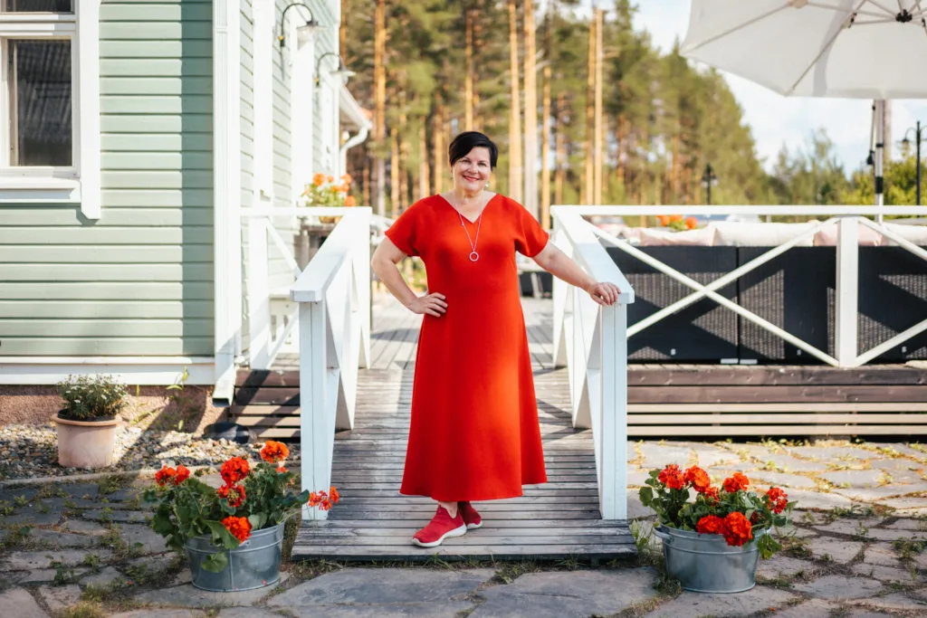 Villa Ruusulan yrittäjä ja taiteilija Sari Kaasinen päärakennuksen edessä. Kaasinen järjestää kantelekursseja ja -työpajoja.