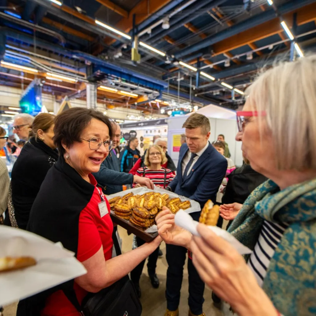 Valamon isä Stefanos ja ampumahiihtäjä Kaisa Mäkäräinen Matkamessuilla Helsingin messukeskuksessa – Valamon luostari ja Pohjoinen Saimaa esillä messuvieraille.