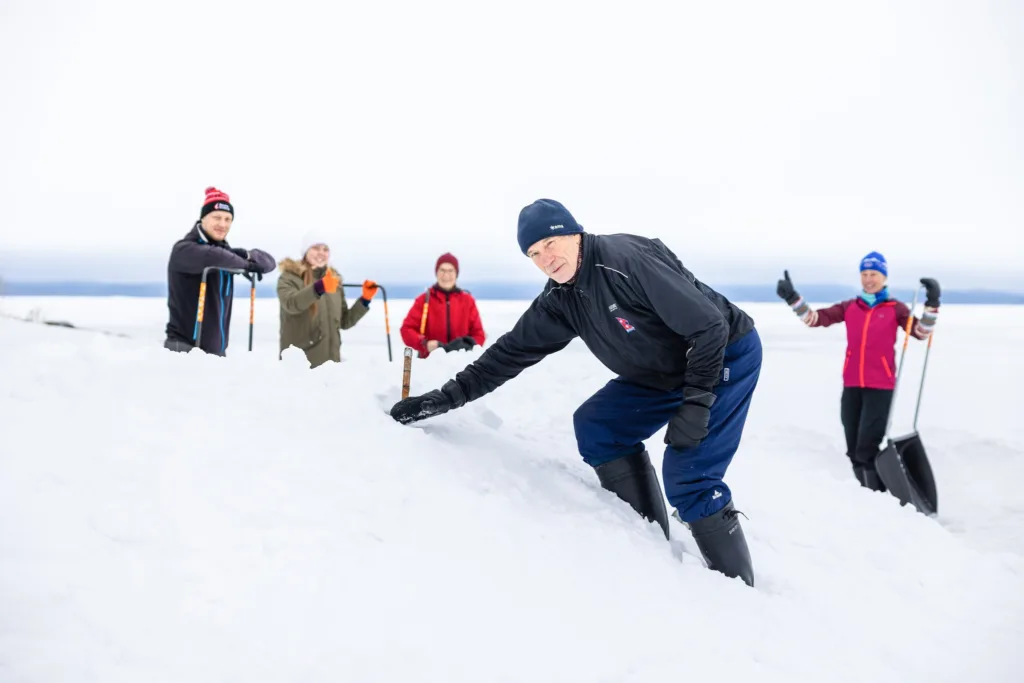 Karelia Cottagesin talviretkellä kolataan pesäpaikkoja saimaannorpille Pohjoisen Saimaan jäällä – vastuullista retkeilyä ja uhanalaisen lajin suojelua.