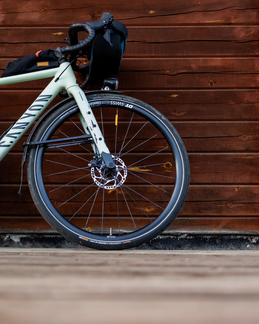 Polkupyörä nojaa hirsiseinää vasten syksyisessä maisemassa Pohjois-Karjalassa – koe Pohjoisen Saimaan pyöräilyreitit.