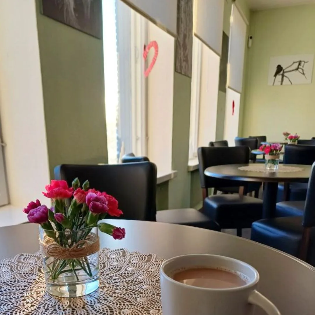 Kahvilasali kokouksiin tai juhliin, kahvikuppi pöydällä.