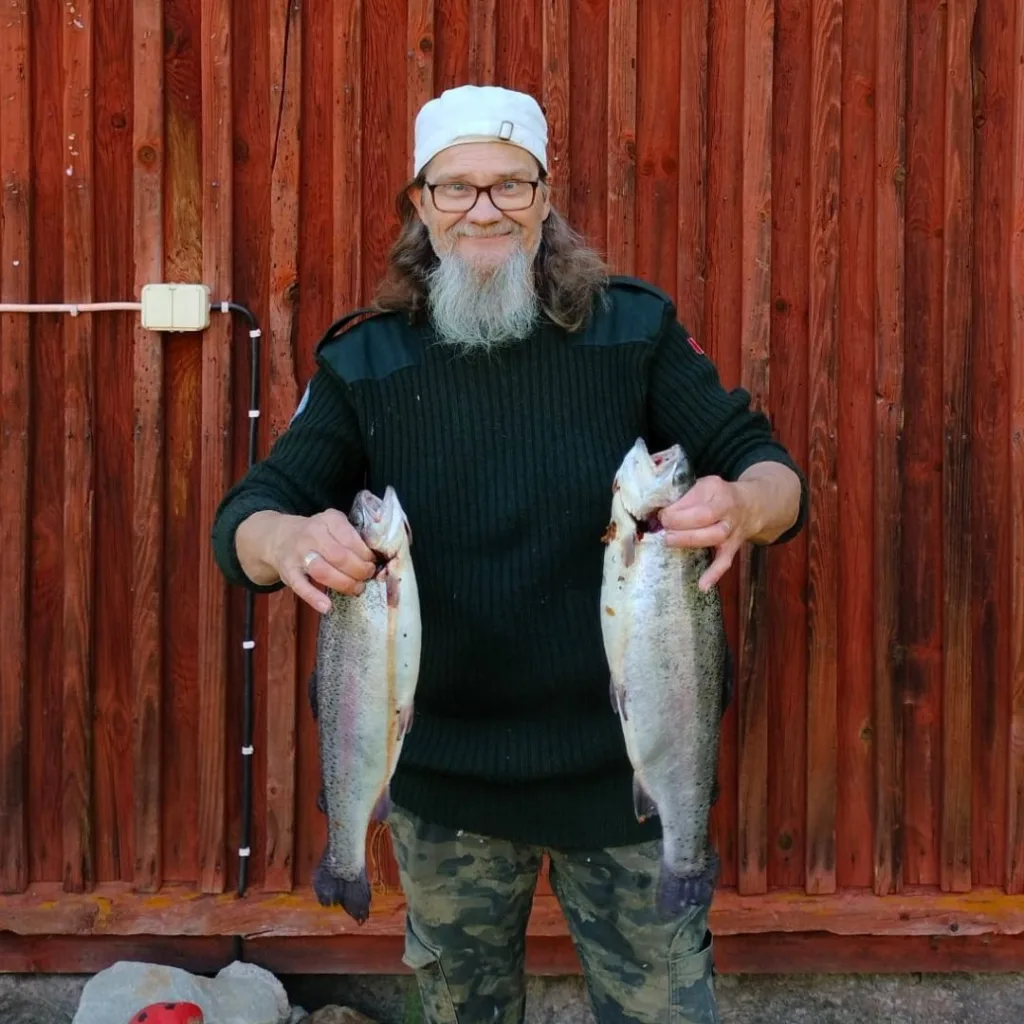 Kalastusopas Jouko pitää kahta kirjolohta Palokin majatalon läheiseltä lohilammelta.