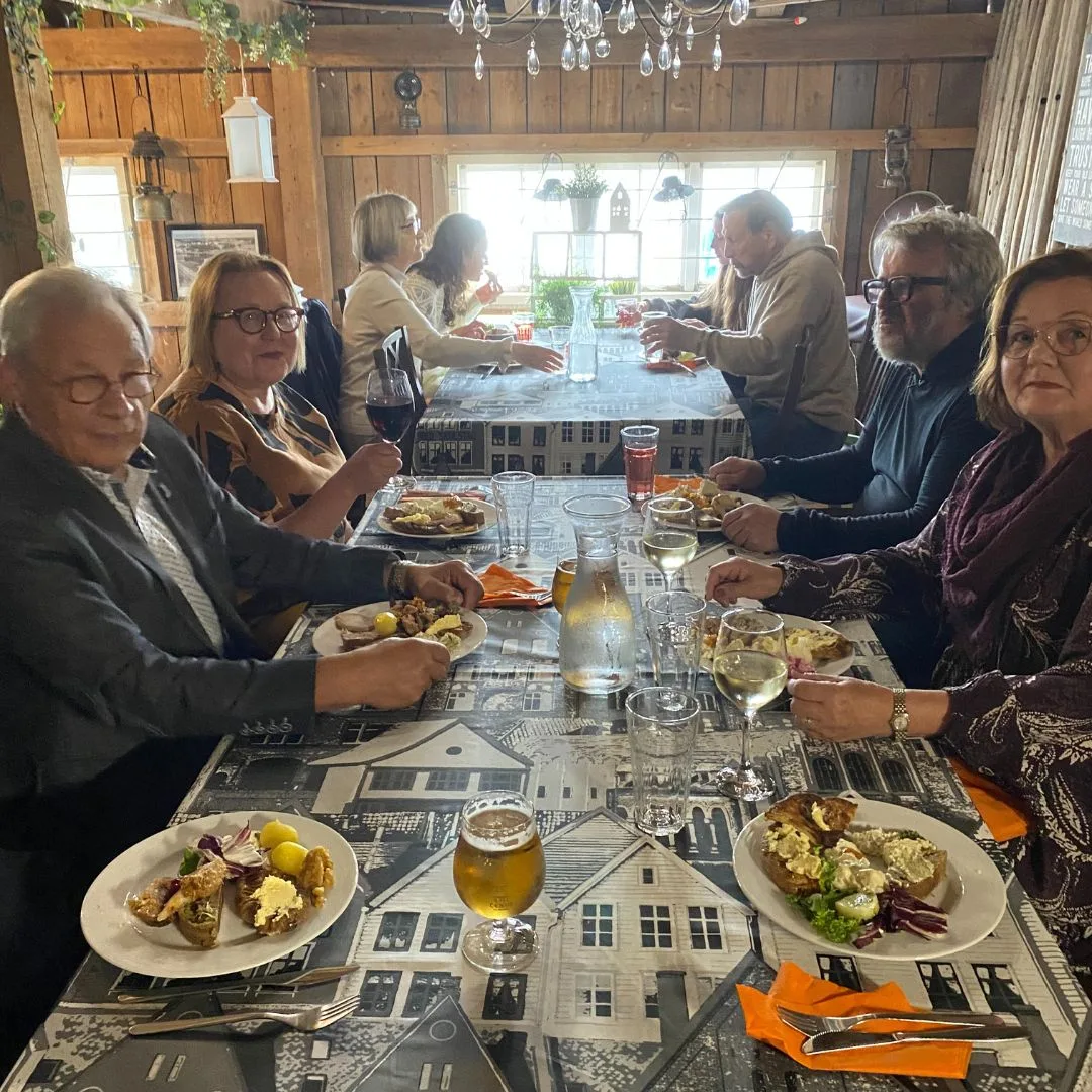 Seurue syö karjalaista pitopöytää Kirkkolahden sataman juhlatilassa.