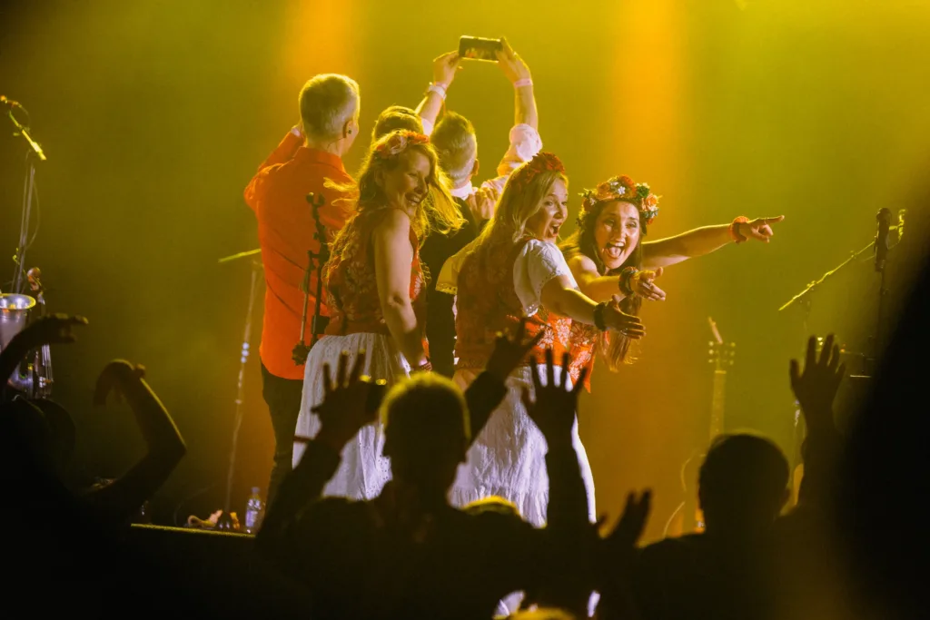 Värttinä-kansanmusiikkiyhtye esiintyy lavalla värikkäissä puvuissaan Pohjois-Karjalassa – tutustu elämyksiin Näe ja koe -sivulta.