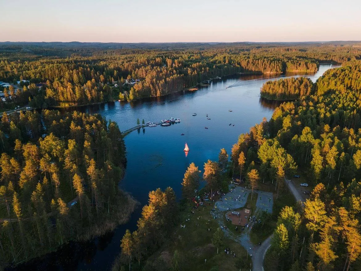 Ilmakuva Karvion leirintäalueesta Heinävedellä Pohjoisella Saimaalla, järvimaisema ja vierasvenelaituri näkyvät vesistön rannalla.