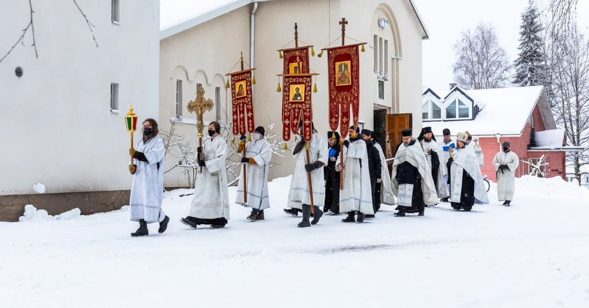 Ristisaatto etenee talvisessa maisemassa Valamon luostarin kirkon edessä Heinävedellä Pohjoisella Saimaalla – ortodoksinen perinne ja yhteinen hiljentymisen hetki.