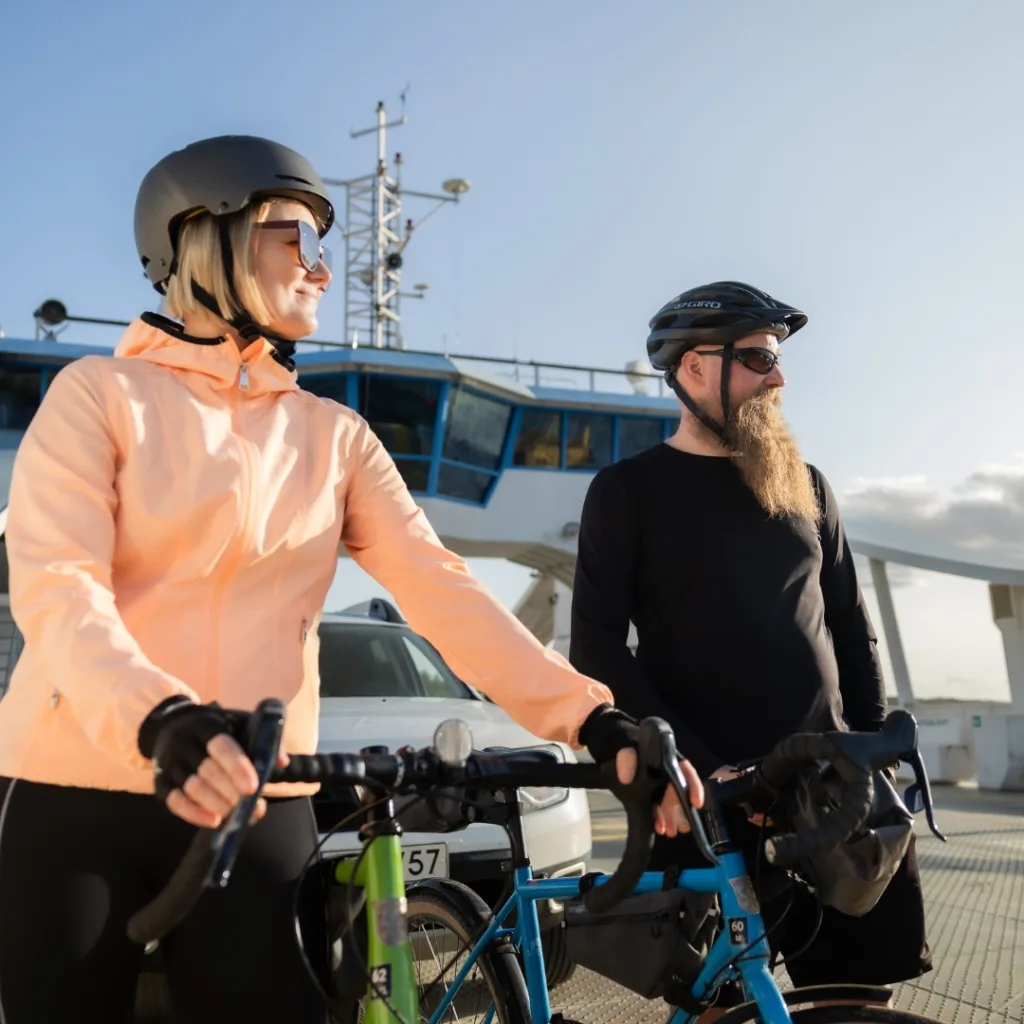 Pariskunta pyörillä Arvinsalmen lossilla Liperin ja Heinäveden välillä Pohjois-Karjalassa – vastuullisia kulkuyhteyksiä julkisilla ja pyörillä.