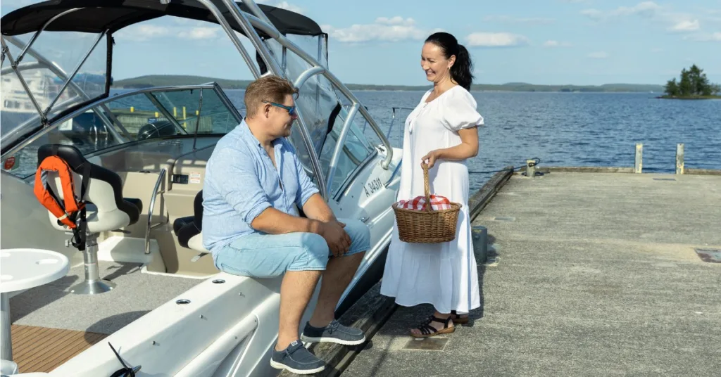 Pariskunta venelaiturilla Heinävedellä Pohjois-Karjalassa – rouva ojentaa eväskoria miehelle sataman tunnelmassa.
