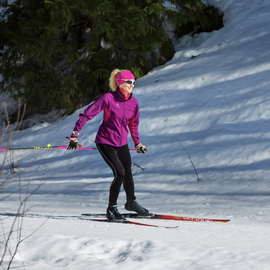 Nainen hiihtää iloisena Liperin hiihtoladuilla Pohjois-Karjalassa.